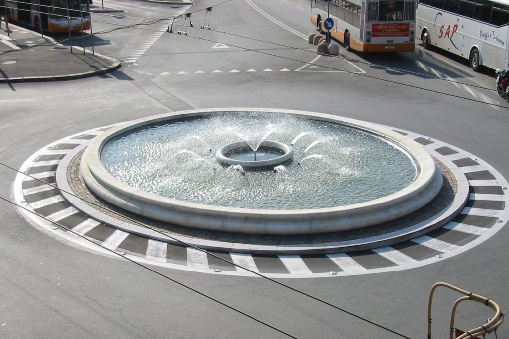 Roundabout fountain with water jets. Artistic fountains enhance urban spaces.