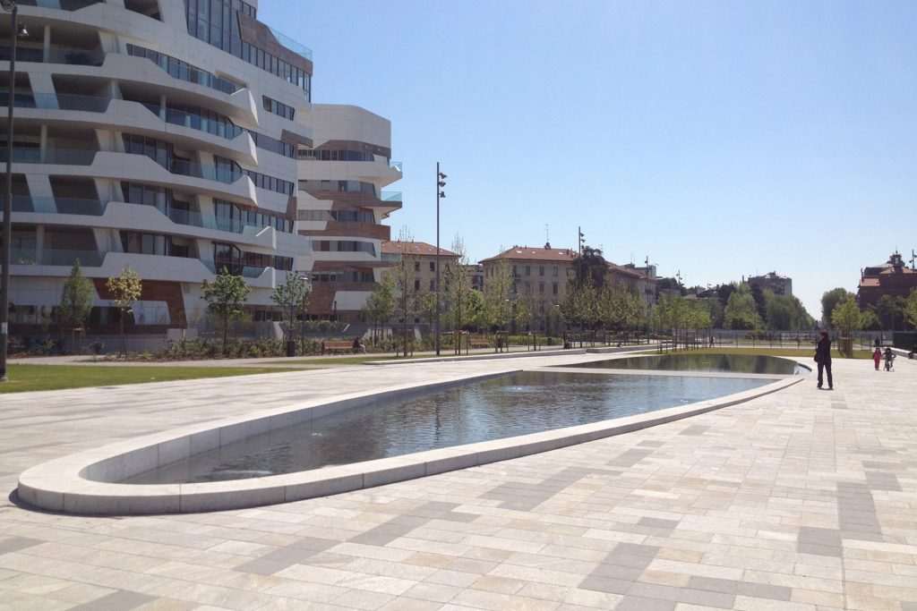 Modern artistic fountain in an urban park with surrounding buildings