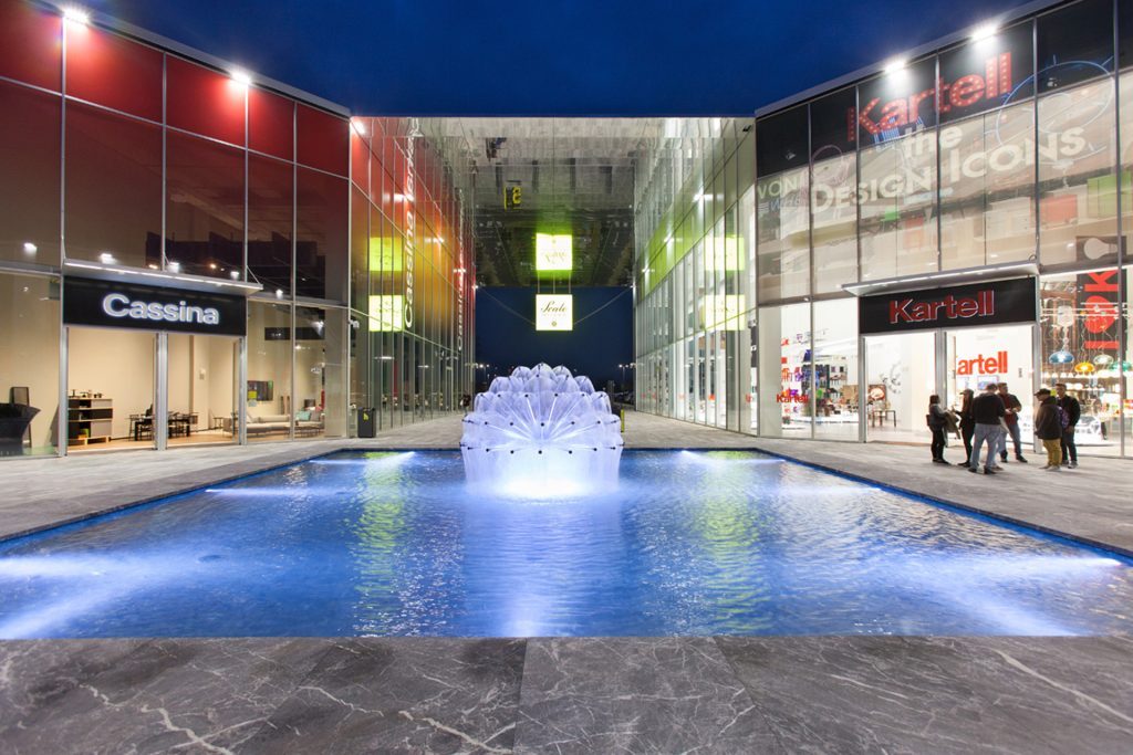 Modern fountain with artistic water feature outside designer stores.